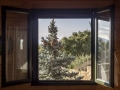 View of the mountains, spruce and forest through an open, wooden window on a sunny autumn day close-up